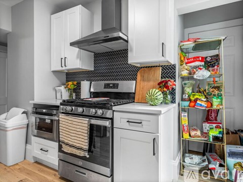 A kitchen with a stove, oven, and refrigerator filled with items.