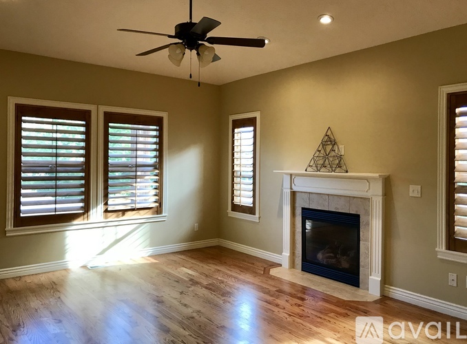 A room with a fireplace and a ceiling fan.