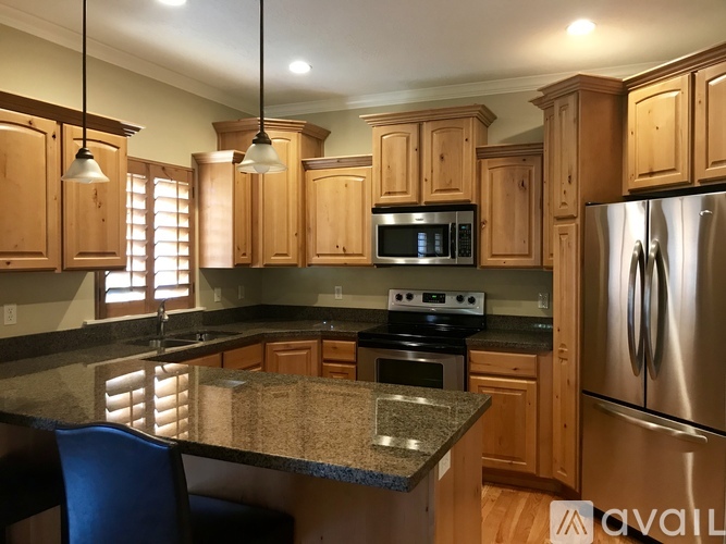 A kitchen with wooden cabinets and a granite countertop.