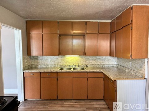 A kitchen with wooden cabinets and a marble countertop.