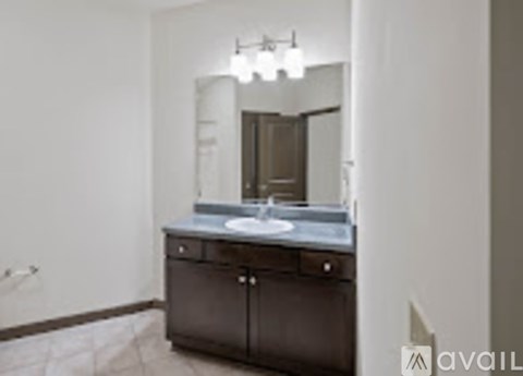A bathroom vanity with a mirror and lights above it.
