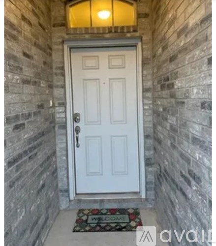 A white door with a glass window above it and a doormat below it.