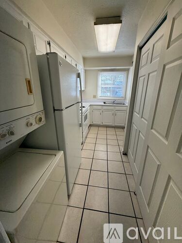 A kitchen with white appliances and cabinets.
