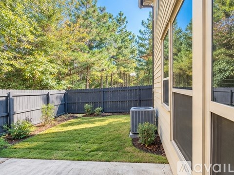 A house with a fence and trees in the background.