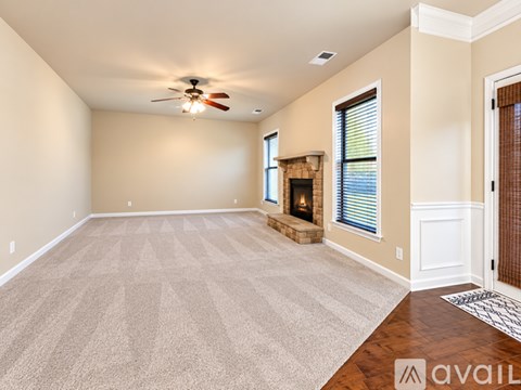 A spacious living room with a fireplace and a carpeted floor.