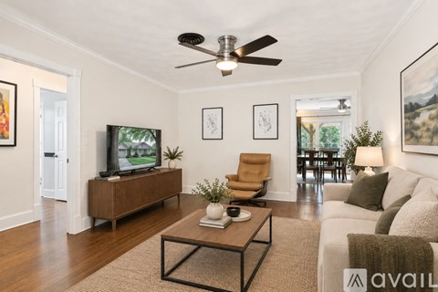 A living room with a brown coffee table and a white couch.