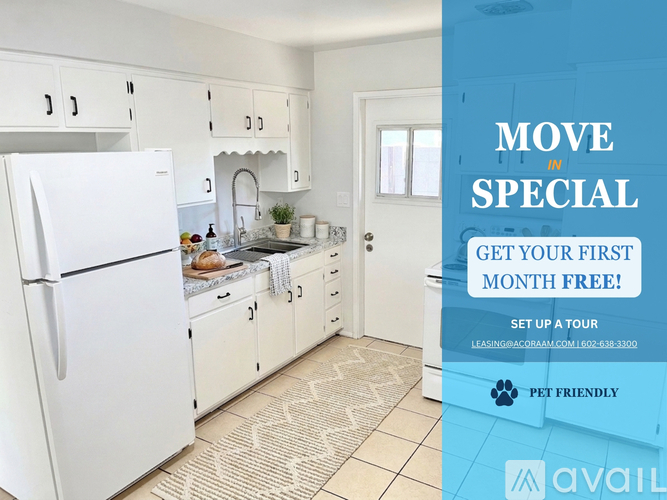 A kitchen with a refrigerator, sink, and cabinets is on display for a move-in special.