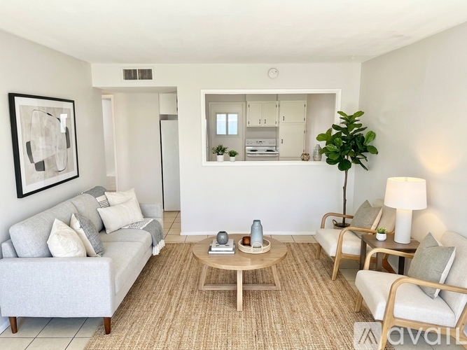 A living room with a grey couch, a wooden coffee table, and a lamp.
