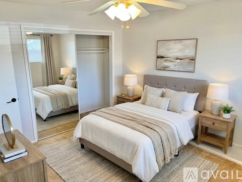 A bedroom with a large bed and a mirror on the wall.