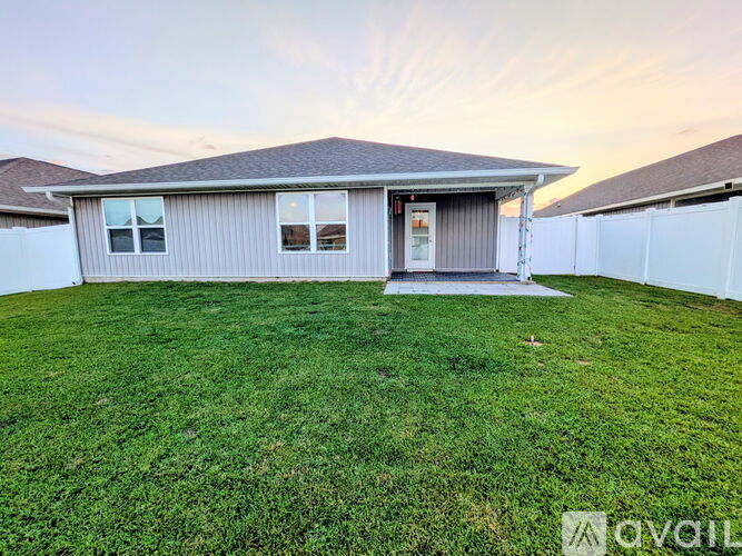 A house with a grey roof and a white fence.