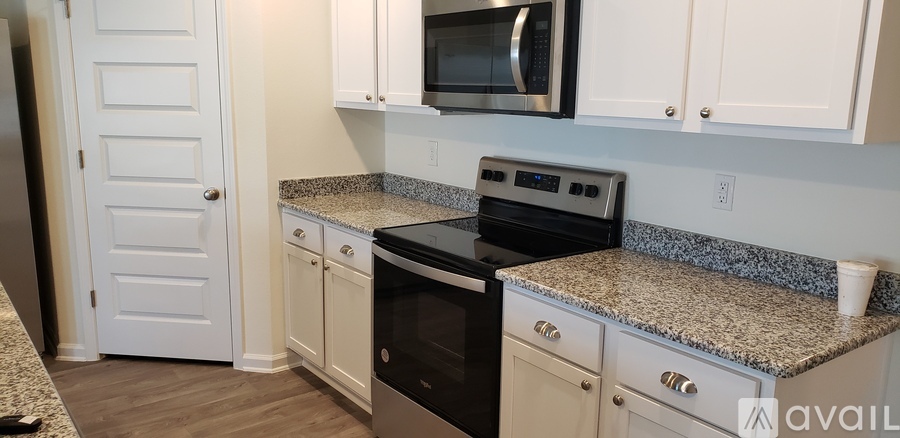 A kitchen with granite countertops and white cabinets.