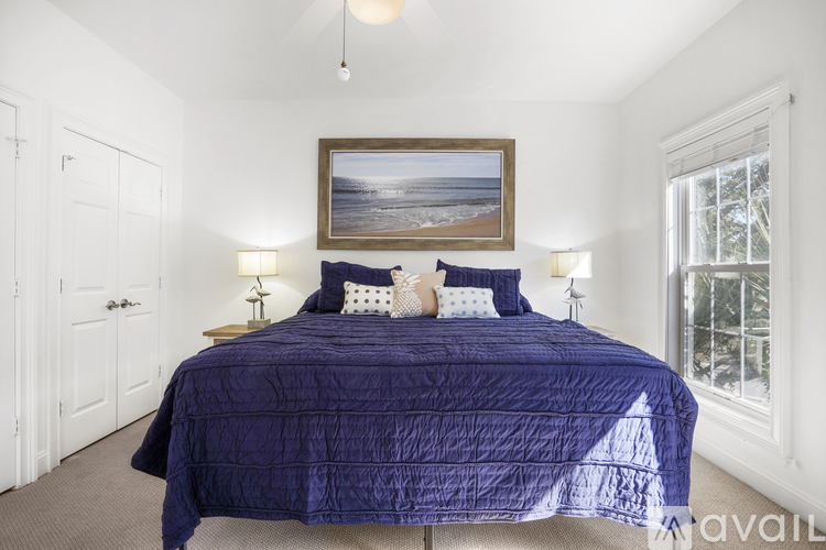 A bedroom with a large bed and a painting on the wall.