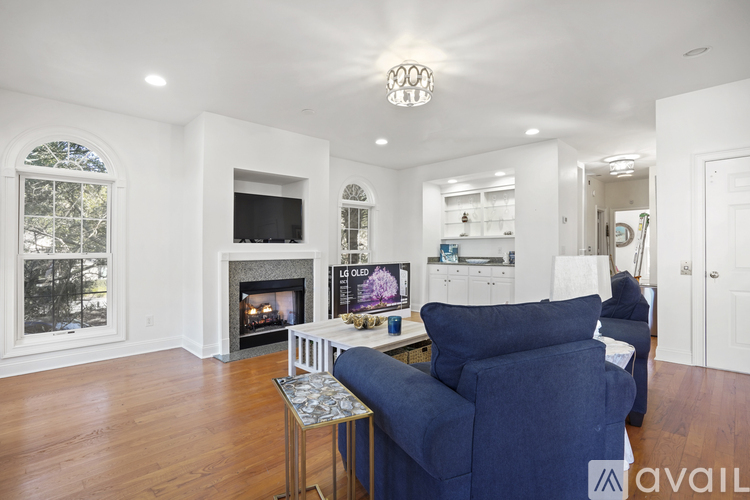 A living room with a fireplace and a blue couch.