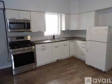A kitchen with white cabinets and a stainless steel oven.