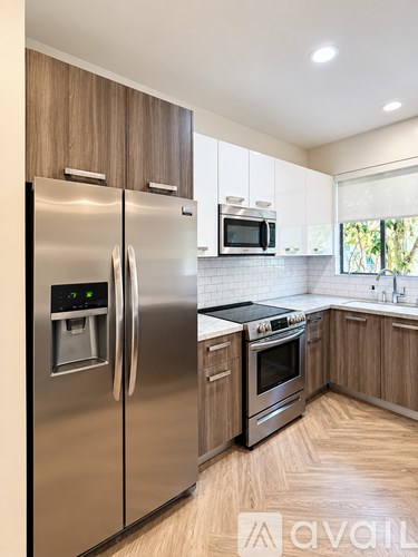 A modern kitchen with a stainless steel refrigerator and wooden cabinets.