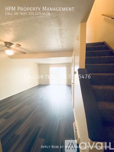 A room with a staircase and a ceiling fan.