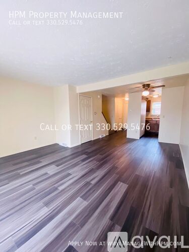 A room with wooden flooring and a doorway leading to another room.