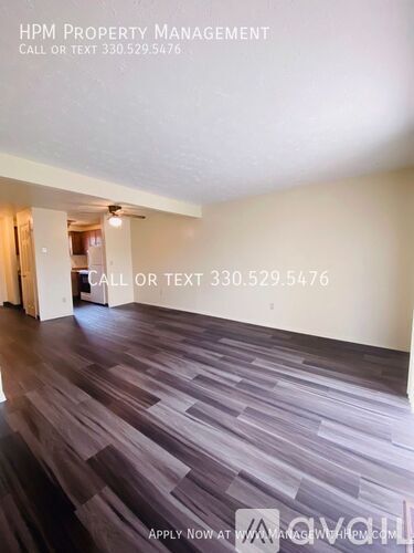 A room with wooden flooring and a sign for HPM Property Management.