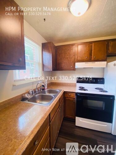 A kitchen with wooden cabinets and a white stove top oven.