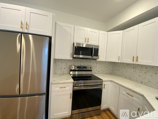 A kitchen with a stainless steel refrigerator, microwave, and oven.