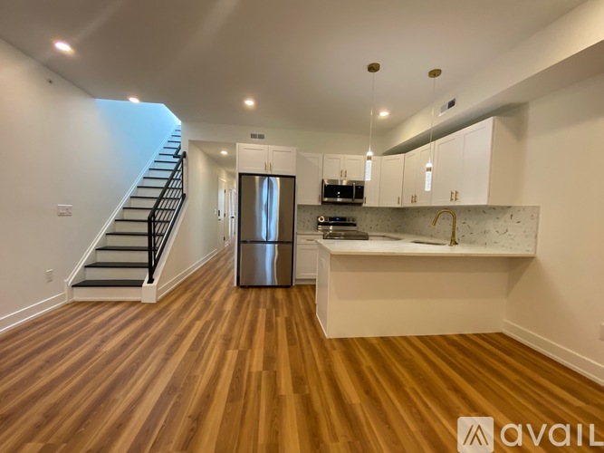 A kitchen with a refrigerator, microwave, and cabinets is available for rent.