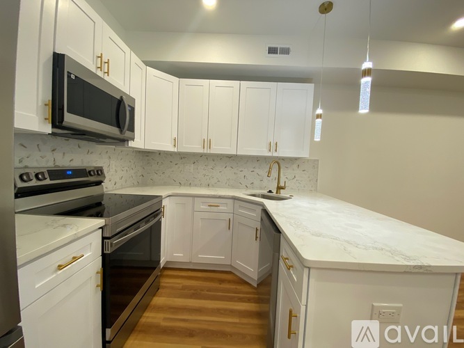 A kitchen with white cabinets and a marble countertop.