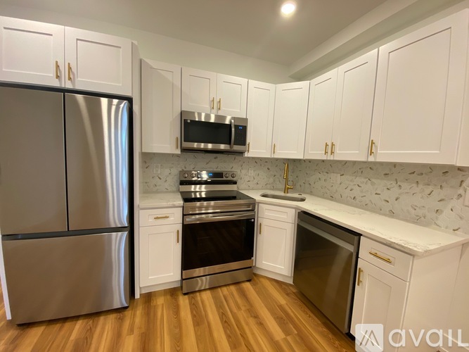 A kitchen with white cabinets and a stainless steel refrigerator.
