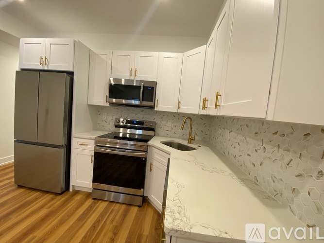 A kitchen with a refrigerator, oven, and microwave.