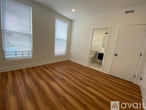 A room with wooden flooring and a white door.