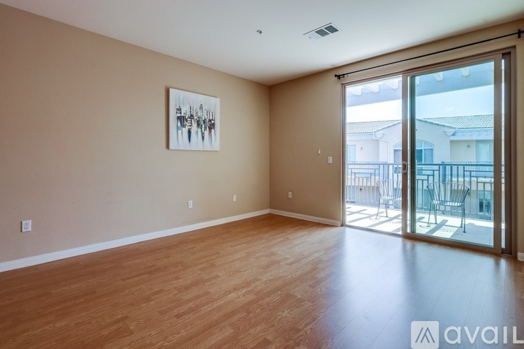 A room with wooden flooring and a painting on the wall.