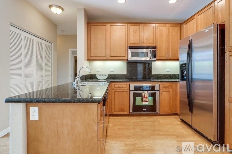 A kitchen with wooden cabinets and a black granite countertop.