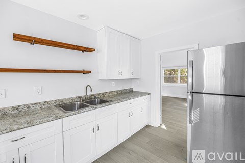 A kitchen with white cabinets and a granite countertop.