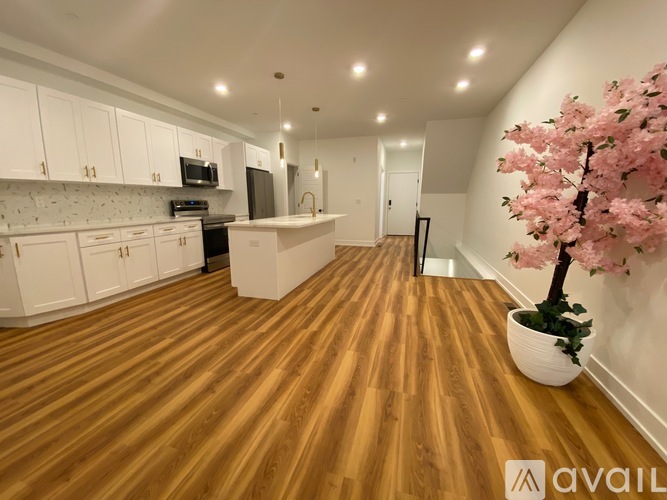 A kitchen with wooden floors and white cabinets.
