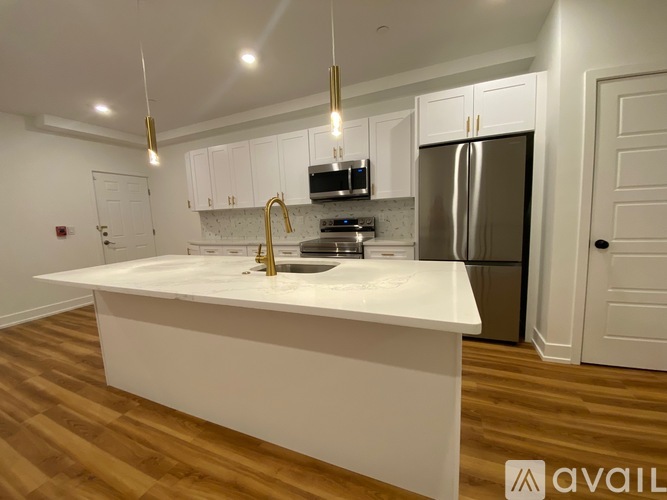 A kitchen with white cabinets and a white island.