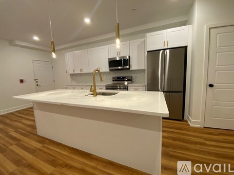 A kitchen with white cabinets and a white island.
