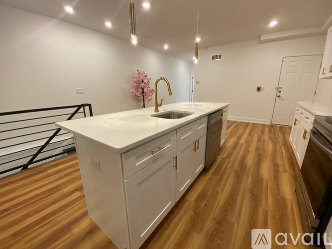 A kitchen with a white countertop and wooden flooring.