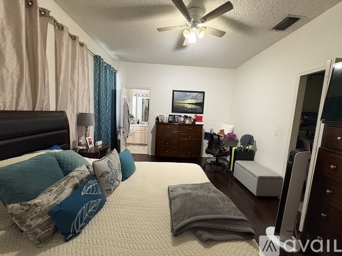 A bedroom with a bed, dresser, and mirror.