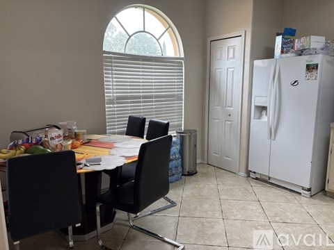 A kitchen with a table and chairs and a refrigerator.