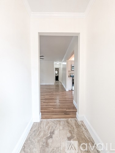 A hallway with a tiled floor and white walls.
