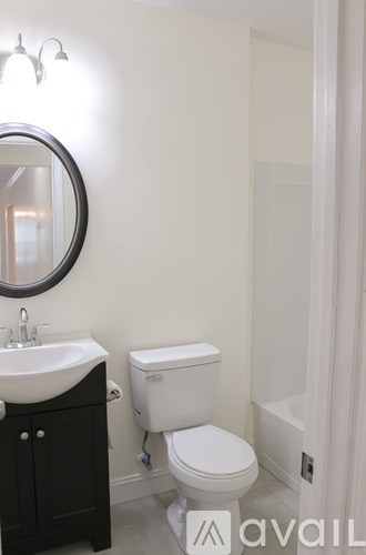 A white toilet sits next to a sink in a bathroom.