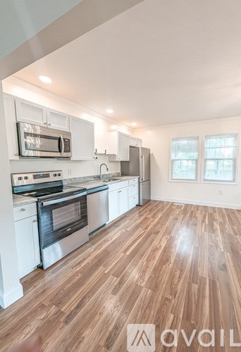 A kitchen with wooden floors and white appliances.