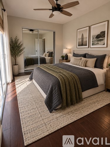 A bedroom with a large bed and a ceiling fan.