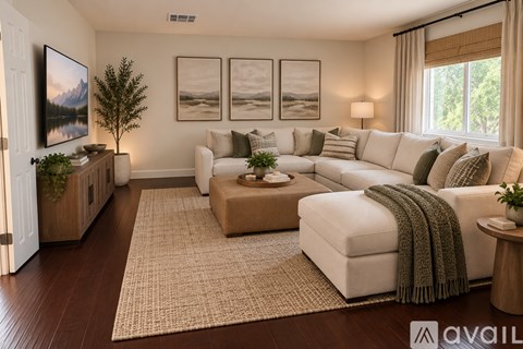 A living room with a white couch, a brown coffee table, and a large painting on the wall.