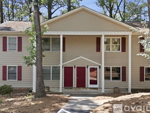 A two-story house with red shutters and a white door.