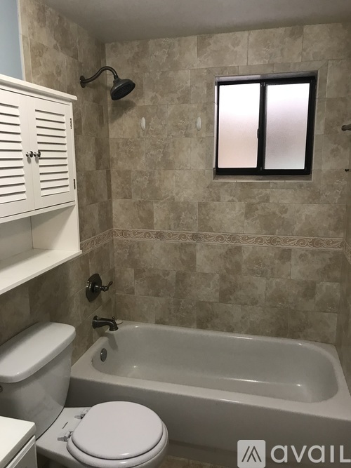 A bathroom with a tub, toilet and sink.