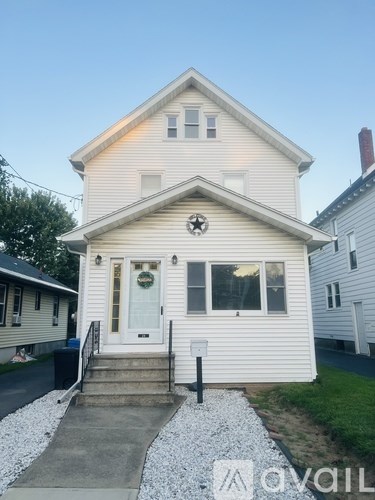 A white house with a front porch and a mailbox.