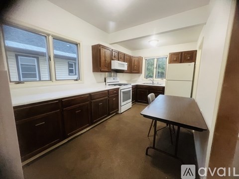 A kitchen with brown cabinets and a table.