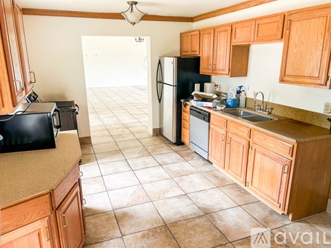 A kitchen with wooden cabinets and a black refrigerator.