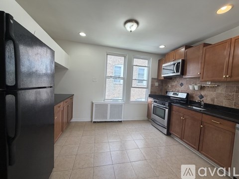 A kitchen with black appliances and wooden cabinets.