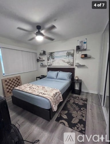 A bedroom with a bed, a ceiling fan, and a rug.